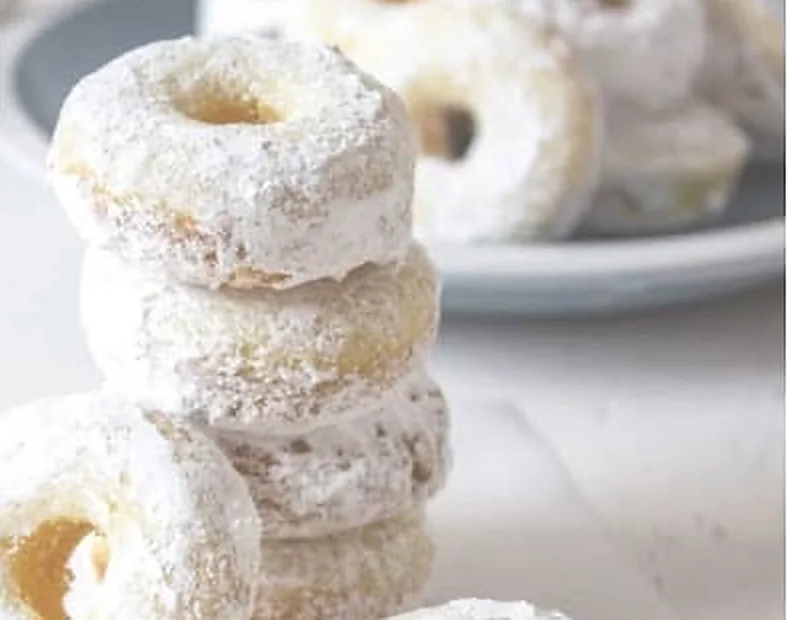 Torre de mini donas cubiertas de azúcar blanca en polvo